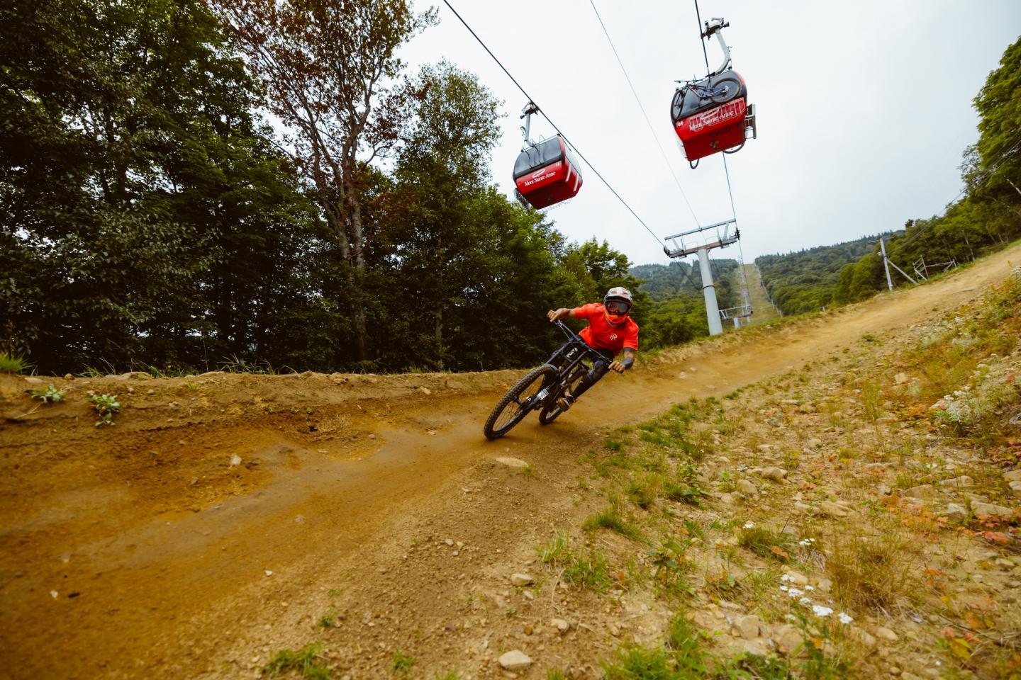 Un cycliste sous les télécabines du Mont-Sainte-Anne.